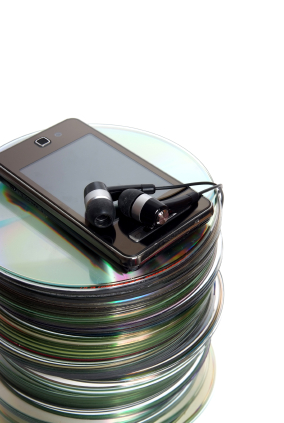 An iPod on top of a stack of CDs